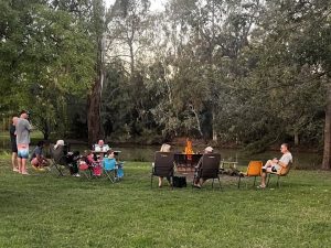denman van village guests around the fireplace on the river