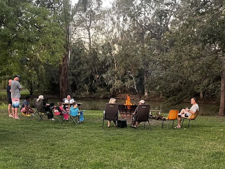 denman van village guests around the fireplace on the river